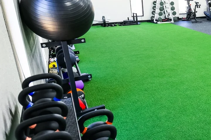 Kettlebells and a stability ball on the turf at Cultivate Wellness & Sports Rehab