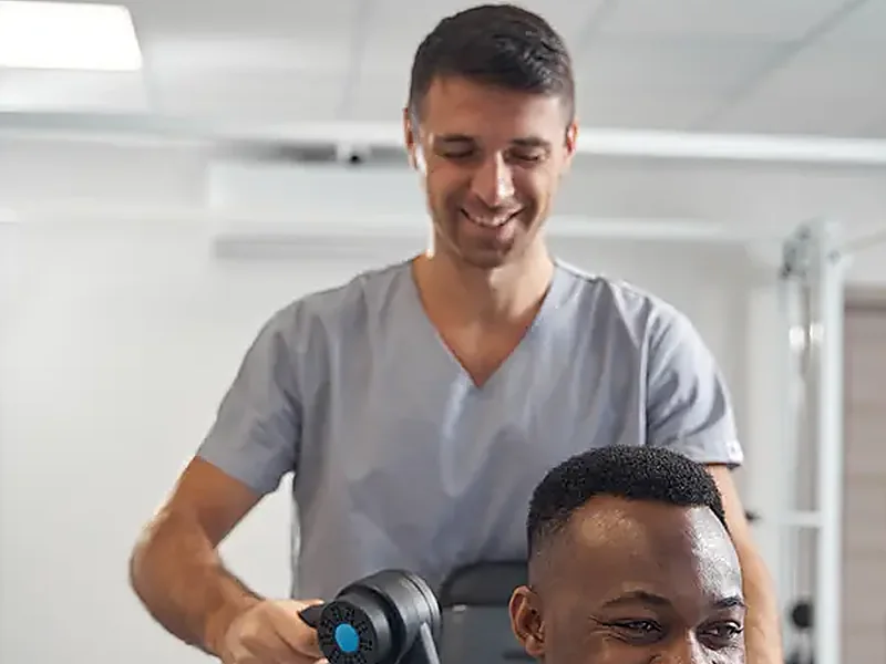 A therapist working hands-on with a seated patient