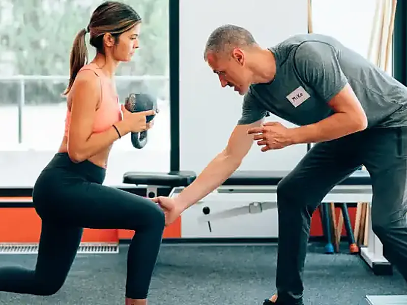 A client being coached through a strength exercise