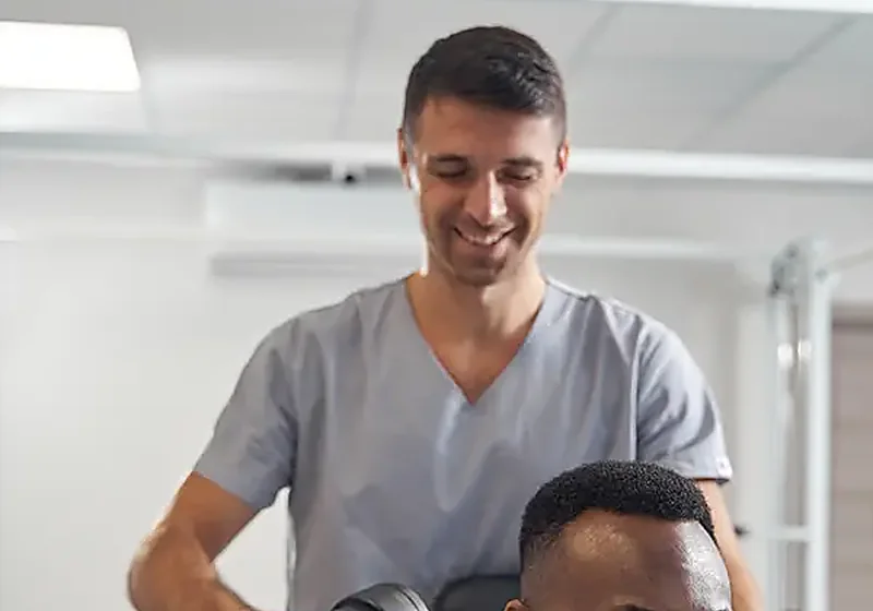 A therapist working hands-on with a seated patient