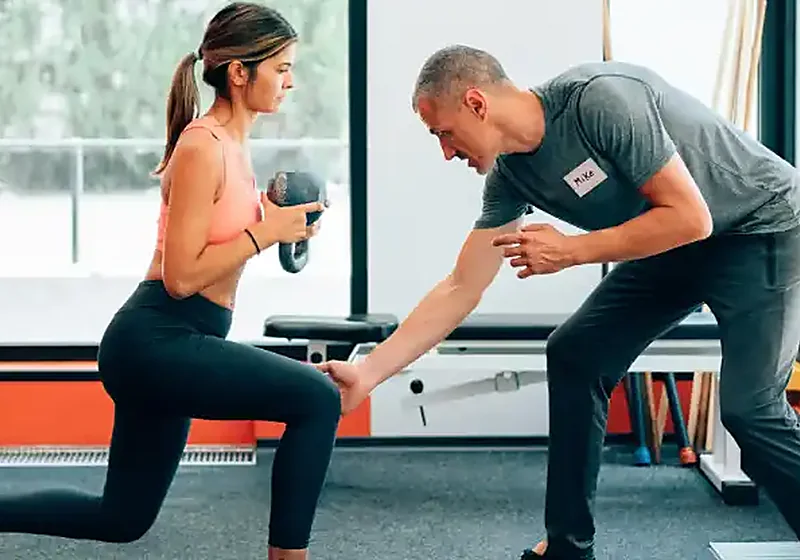Trainer coaching a client through a personal training session