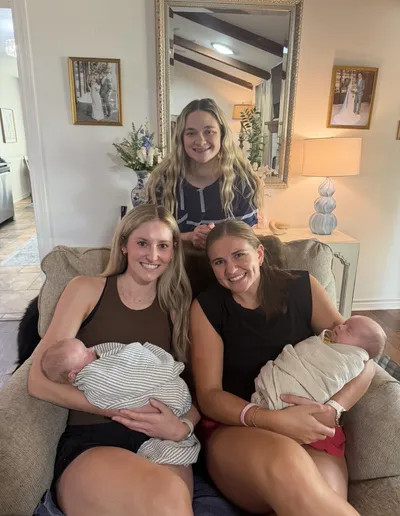 Dr. Jae Karson Brandon holding a newborn at home with loved ones
